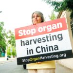 Жінка навпроти посольства КНР закликає припинити примусове вирізання органів у Китаї